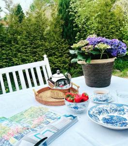 a table with a tea kettle and bowls of fruit at Freya Blue Ferienhaus in Weener