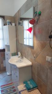 uma casa de banho com um lavatório e um espelho em Paraiso Sardo 1 em Villasimius