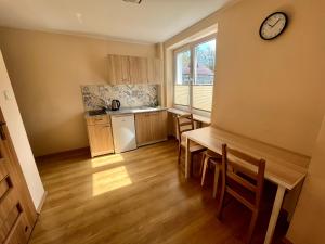 a kitchen with a table and a clock on the wall at Apartament Bryza, Willa Perla 100m od morza in Gdańsk