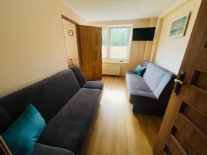 a living room with a couch and a chair at Apartament Bryza, Willa Perla 100m od morza in Gdańsk