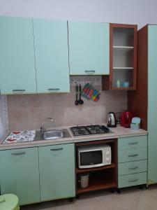 eine kleine Küche mit einer Spüle und einer Mikrowelle in der Unterkunft Domus Rosaliae - Casa Vacanze in Palermo