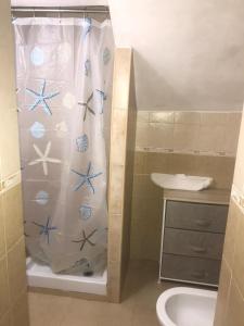 Baño con cortina de ducha con artículos originales en Domus Rosaliae - Casa Vacanze en Palermo