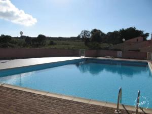 une grande piscine bleue installée à côté d'un bâtiment dans l'établissement Résidence Mare Bellu Agosta plage, à Porticcio