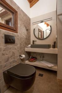 ein Bad mit einem schwarzen WC und einem Spiegel in der Unterkunft The Knight's House Old Town Rhodes in Rhodos (Stadt) + 31 Fotos