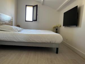 - une chambre avec un lit et une télévision murale dans l'établissement Résidence Mare Bellu Agosta plage, à Porticcio