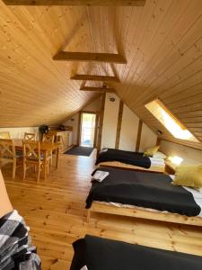 two beds in a room with a wooden ceiling at MotoMotel-Myczkowianka Sadyba in Myczkowce