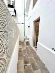 a hallway with a white wall and a tile floor at Guest house Le due lagune in Orbetello +50 photos
