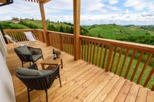 una terraza de madera con 2 sillas y una mesa. en Weingut Dreisiebner Stammhaus, en Gamlitz