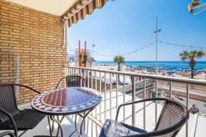 a balcony with a table and chairs and the beach at Los Ranchos in Benidorm