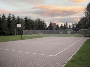 a tennis court with a net on top of it at Domki nad morzem CELLO in Ostrowo