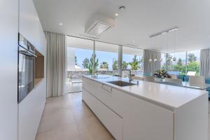 a kitchen with white cabinets and a large kitchen island at Villa Abama in Tejina de Isora