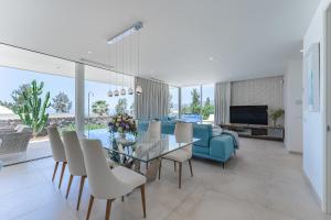 a living room with a glass table and a blue couch at Villa Abama in Tejina de Isora