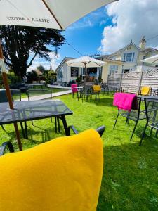 un grupo de mesas y sillas y una sombrilla en Anchorage Hotel, en Torquay