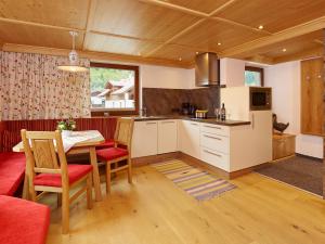 een keuken met een tafel en stoelen in een kamer bij Appartements Alpenrose in Längenfeld