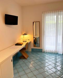 a desk with a lamp and a mirror in a room at Ganimede Hotel in Sperlonga