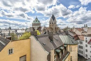 einen Blick auf die Dächer von Gebäuden in einer Stadt in der Unterkunft Hotel ADRIA München in München