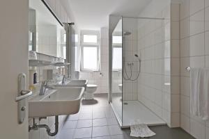 a white bathroom with three sinks and a shower at City Partner Central-Hotel Wuppertal in Wuppertal