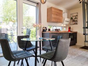 een keuken en eetkamer met een glazen tafel en stoelen bij Vakantiewoning De kleine Vos MB02 in Middelburg
