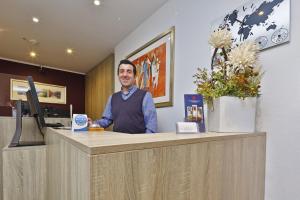 a man is standing at a counter in a salon at City Partner Central-Hotel Wuppertal in Wuppertal