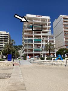 a white building with an arrow pointing to a hotel at Beachfront and Renovated Apartment in Cullera