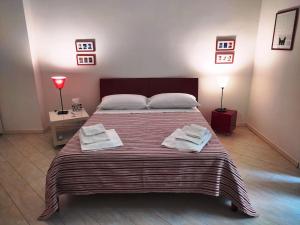 una camera da letto con un grande letto con due asciugamani di Casa Torrenapoli a Napoli