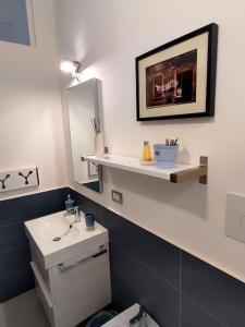 bagno con servizi igienici, lavandino e specchio di Casa Torrenapoli a Napoli