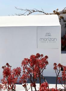 a display of red flowers in front of a box at Marizan Caves & Villas in Oia