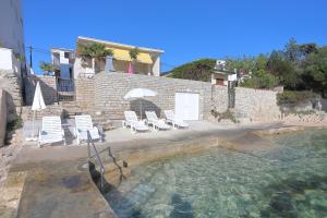 a house with a swimming pool with chairs and an umbrella at Beach House Adria in Bibinje