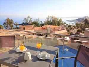 einen Tisch mit zwei Gläsern Orangensaft auf dem Balkon in der Unterkunft New 2023 Bay View Luxury Apt, Sea Views & Pool in Benalmádena