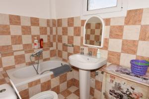 a bathroom with a sink and a tub and a toilet at Hermes Apartment -1 in Nafplio +48 photos