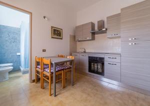 a kitchen with a table and chairs and a stove at A Casa di Giò - Murphy Holiday Home in La Maddalena