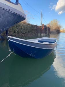 a blue boat is docked in the water at Péniche Le Pescalune - Chambre d'hôtes in Arles