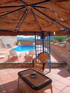 un patio con mesa, sillas y piscina en EL CONVENTO Vivienda Rural Jaén Andalucía España en Carchelejo
