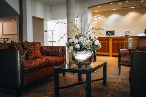 a lobby with a vase of flowers on a table at The Oxfordshire Golf & Spa Hotel in Thame +30 photos