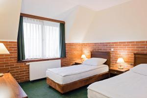 A bed or beds in a room at Hotel Szymbark