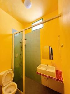 La salle de bains jaune est pourvue de toilettes et d'un lavabo. dans l'établissement Alley51 Hotel, à Surat Thani