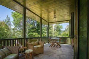 a screened in porch with a table and chairs at Vila Camelia in Golubac