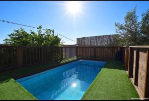 una piscina en un patio con una valla de madera en וילה ויליז'ן, en H̱azon