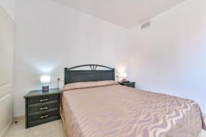 ein Schlafzimmer mit einem großen Bett und zwei Nachttischen in der Unterkunft Apartamentos Zafiro Atico (2-12º-C) in Calpe