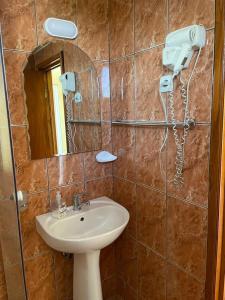 a bathroom with a sink and a mirror at Pensiunea Floare de Colt in Deva +57 photos