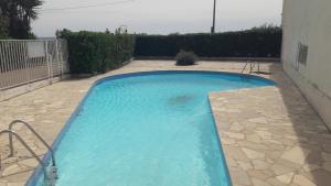 a small blue swimming pool in a yard at Splendide studio front de mer in Menton