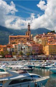 a group of boats docked in a harbor with a city at Splendide studio front de mer in Menton