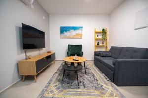 a living room with a couch and a table at PORT CITY HAIFA - Downtown Luxury Apartments - MAMAK in Haifa