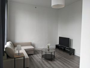 a living room with a couch and a tv at Appart'Huy in Huy