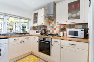 a kitchen with white cabinets and a stove top oven at The Old Dairy in Ambleside