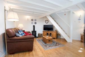 a living room with a couch and a tv at The Old Dairy in Ambleside