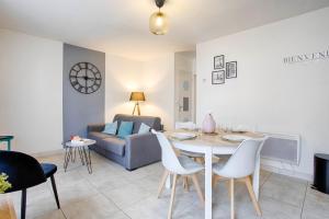 a living room with a table and chairs and a couch at Le Grand Appart' proche commerces in Flers +28 photos