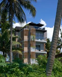 a building on the beach with palm trees at Harding Boutique Hotel in Ahangama