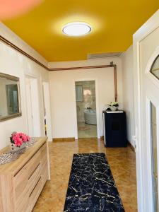 une salle de bains avec un plafond jaune et une chambre dans l'établissement Apartman Kula, à Gradačac