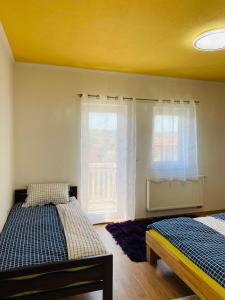 - une chambre avec 2 lits et une fenêtre dans l'établissement Apartman Kula, à Gradačac